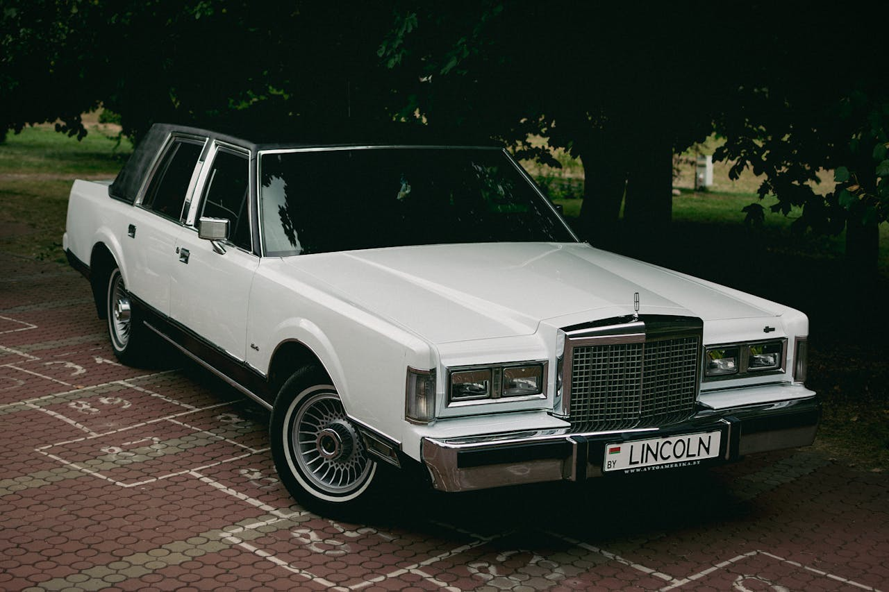 Vintage white Lincoln limousine parked in a serene Minsk park.